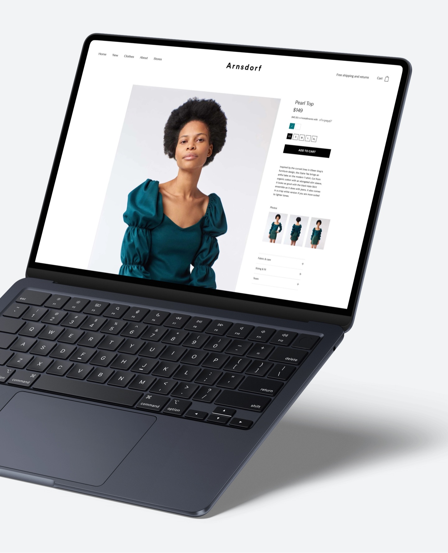 Arnsdorf: laptop showing the online store, with a model in a teal Pearl Top