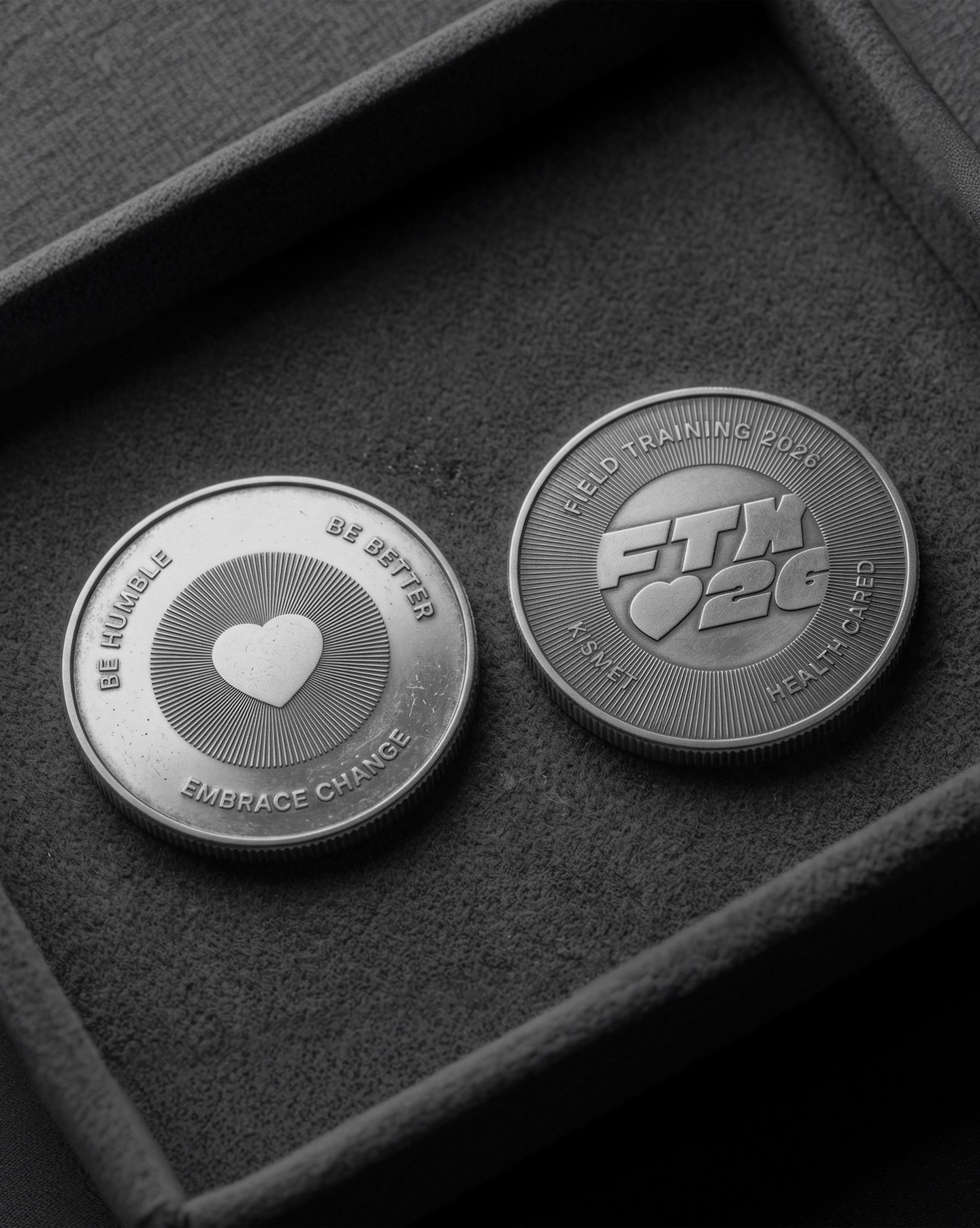 Kismet: two silver coins in a velvet tray, one with a heart and one marked FTX 26 Field Training