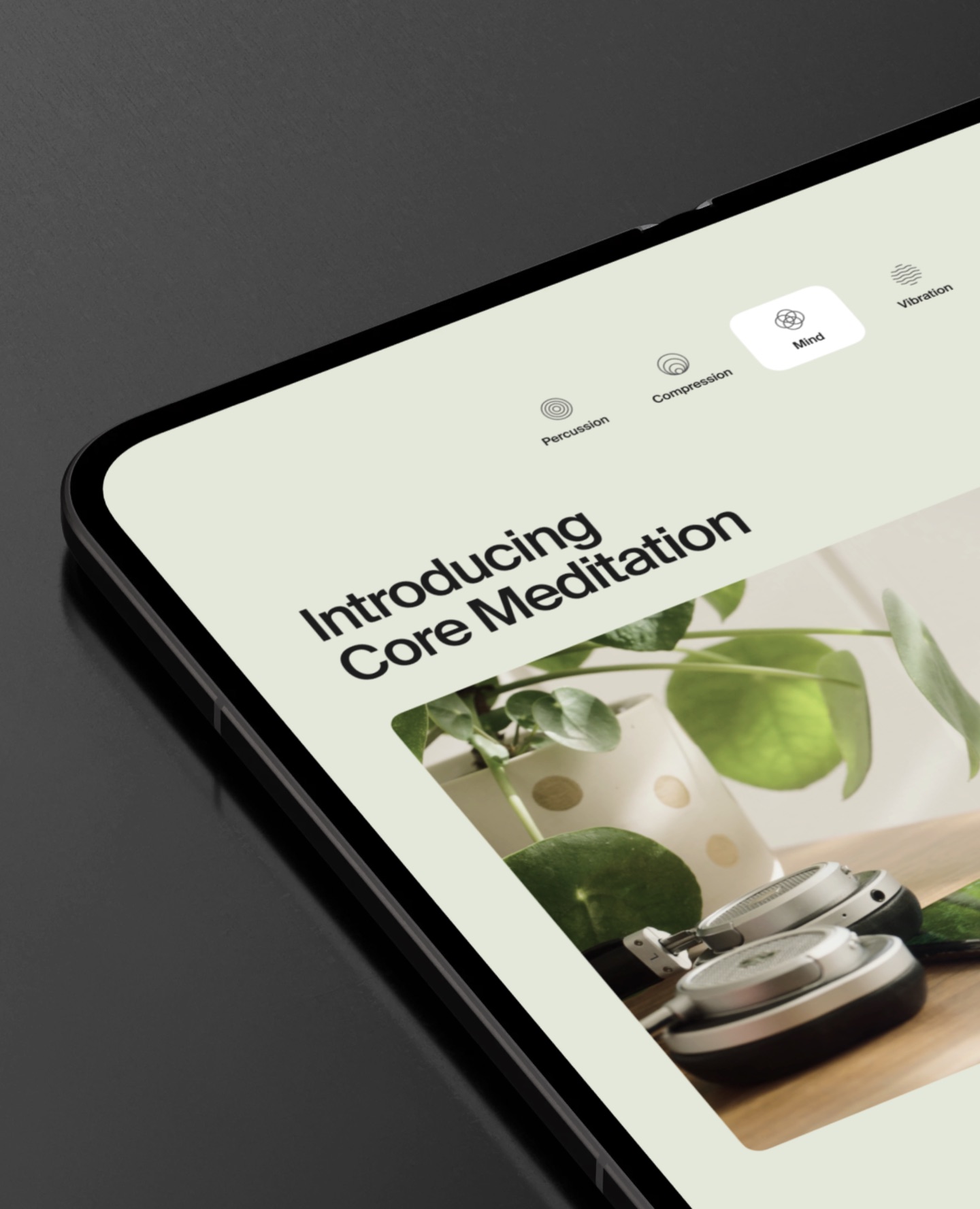 Tablet showing a Hyperice page, Introducing Core Meditation, with headphones and plants