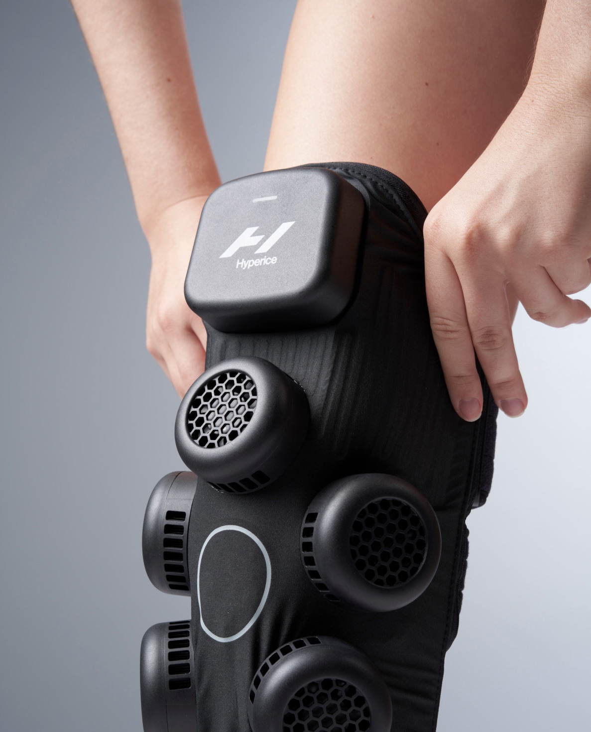 Hyperice compression and heat wrap with vented pods, being fitted around a knee