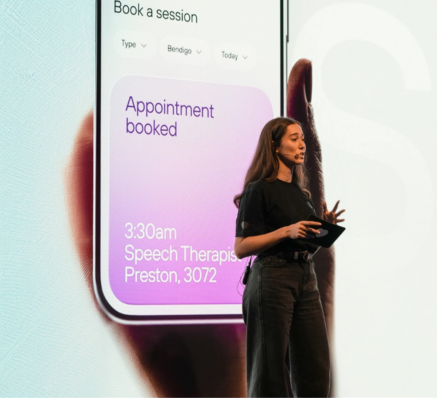 Presenter on stage in front of a large screen showing the Kismet app: Appointment booked, Speech Therapist