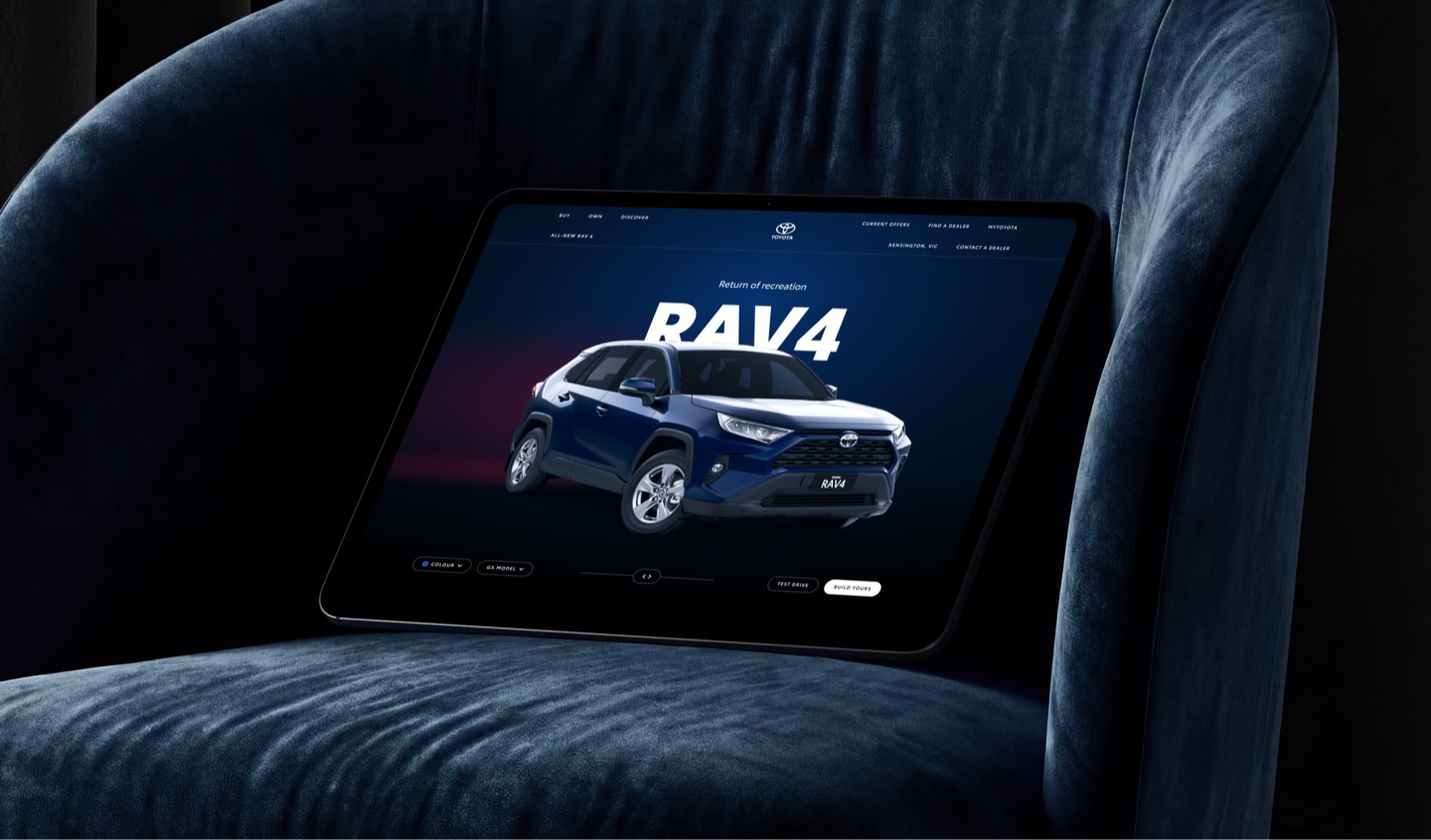 Tablet on a velvet armchair showing the Toyota RAV4 launch page: Return of recreation